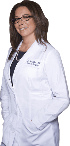 A woman in a white lab coat posing for a photo.